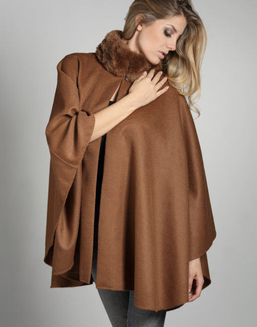 Modelo luciendo la capa Neru Fur de baby alpaca en tono vicuña, mostrando el cuello de piel con elegancia