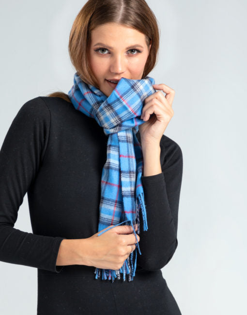 Mujer luciendo chalina escocesa azul de baby alpaca, ideal para clima frío