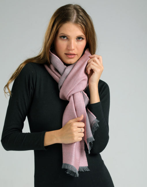 Chalina reversible gris y rosada sobre mujer vestida de negro, luciendo un look moderno