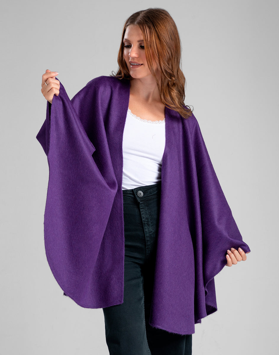Mujer de pie luciendo ruana morada de baby alpaca, vista frontal